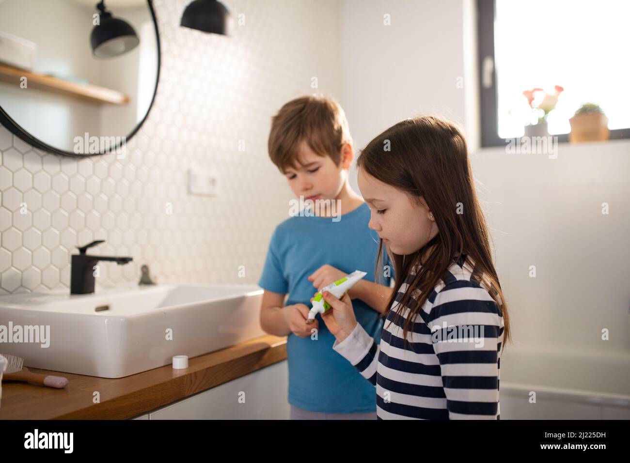 Kleine Geschwister putzen sich im Badezimmer Zähne, morgendliches Routinekonzept. Stockfoto