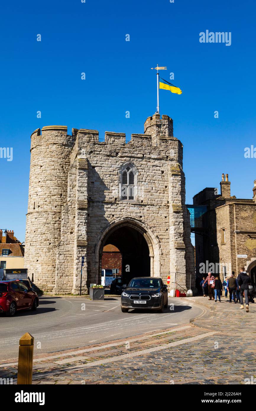 Der Verkehr fährt unter dem Bogen, Westgate Towers, Canterbury, Kent, England. Ukrainische Flagge fliegt zur Unterstützung. Stockfoto