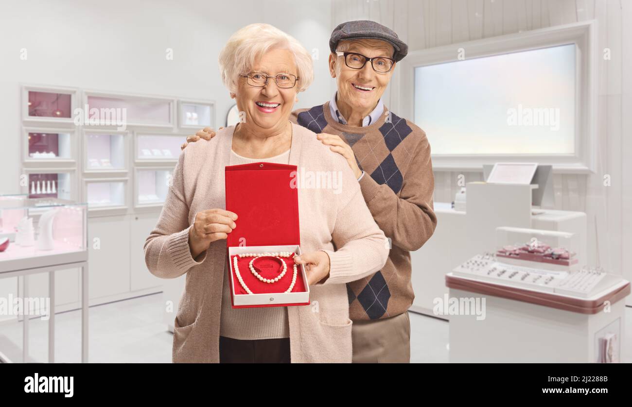 Ein älteres Paar mit einer Perlenkette und einem Armband in einer Schachtel, das in einem Juweliergeschäft steht Stockfoto