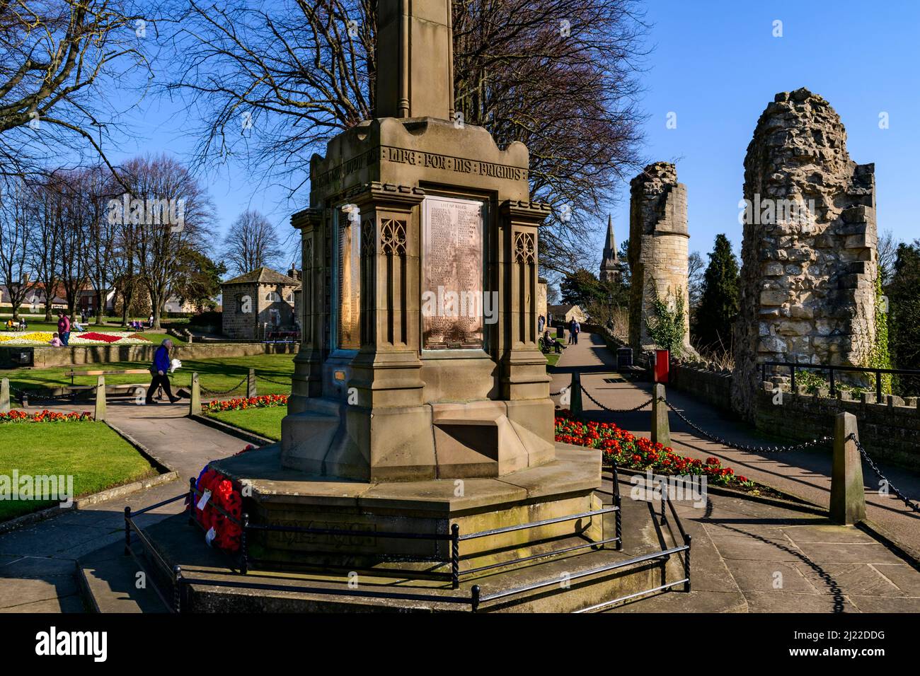 Menschen entspannen Wandern auf Wegen in sonnigen Park (Kriegsdenkmal rote Mohnblumen, alte Ruinen, blauer Himmel) - Knaresborough Castle, North Yorkshire England Großbritannien. Stockfoto