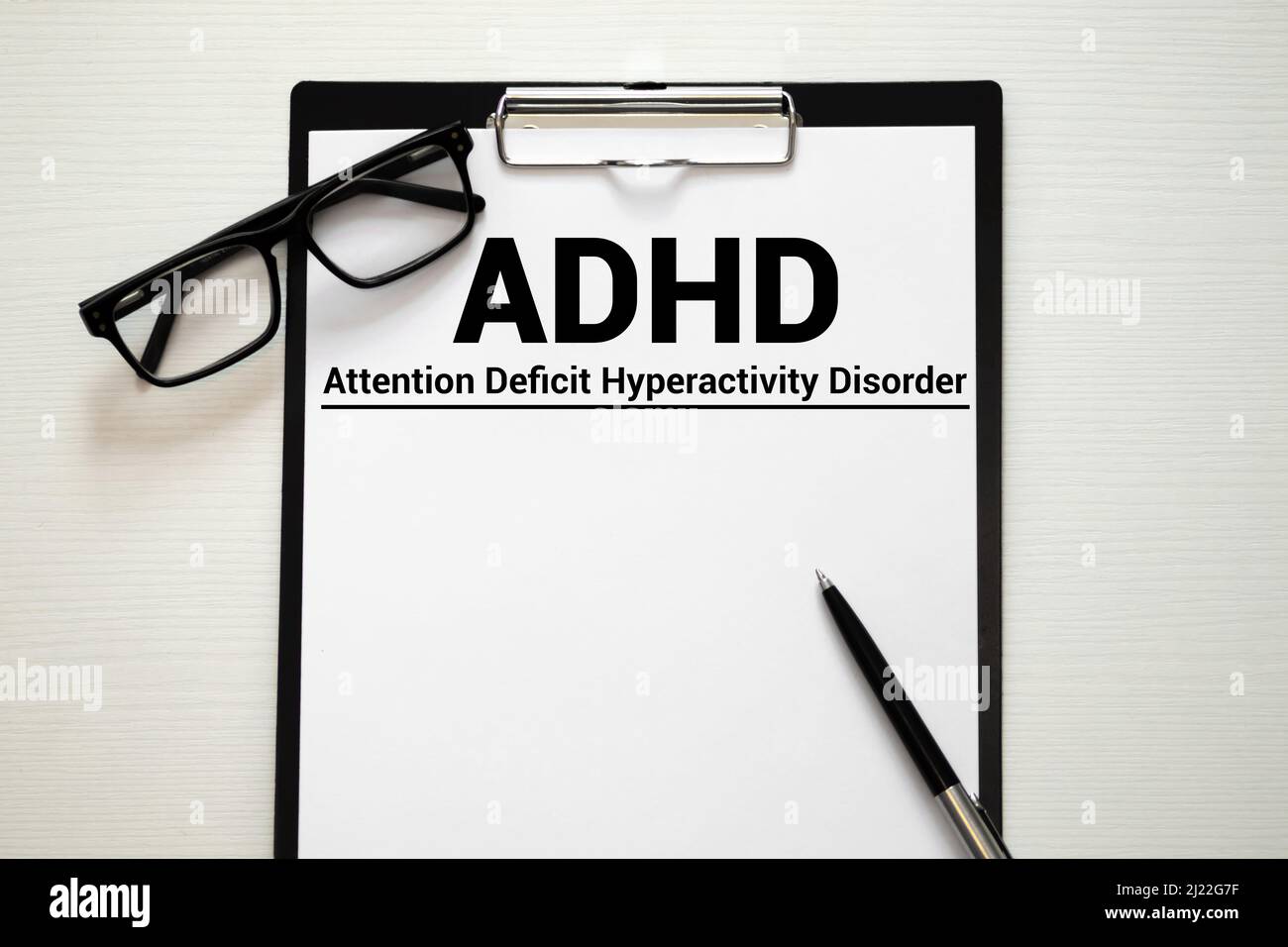 Notebook-Seite mit Text ADHD -  Aufmerksamkeitsdefizit-Hyperaktivitätsstörung, auf einem Tisch mit  Stethoskop und Stift, medizinisches Konzept Stockfotografie - Alamy