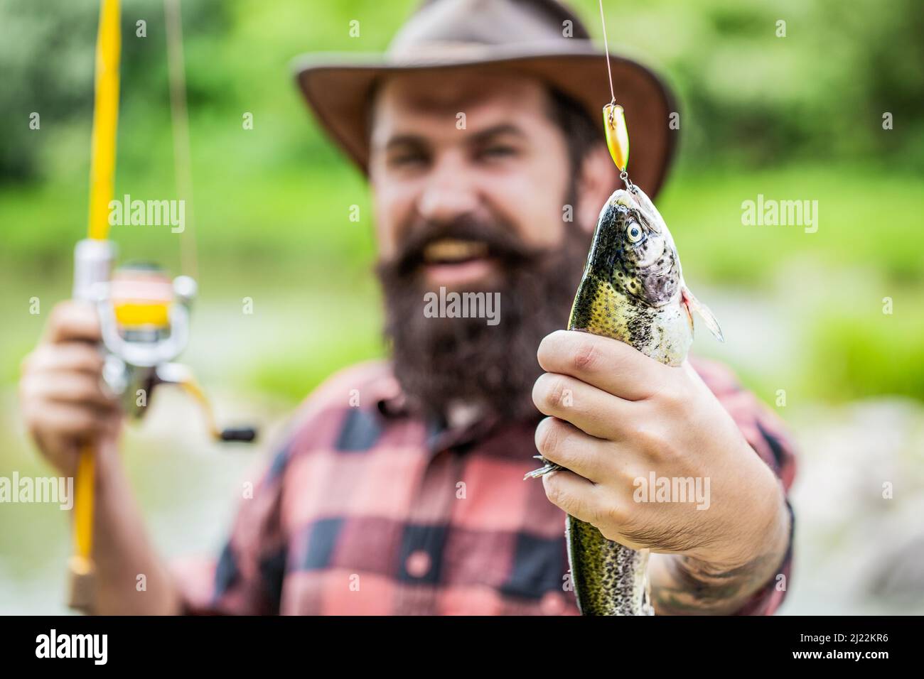 Angeln. Angler mit Angeltrophäe. Fischer und Forelle. Angelhintergründe. Mann hält große Fischforelle in den Händen. Fischer und Trophäe Forelle. Mann Stockfoto