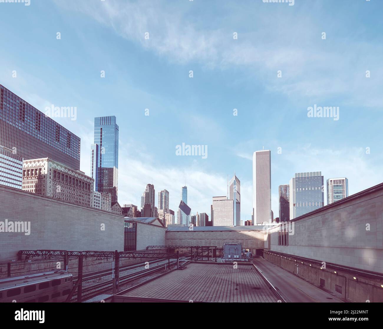 Eisenbahnschienen mit Chicagos Skyline in der Ferne, Farbtonung angewendet, USA. Stockfoto