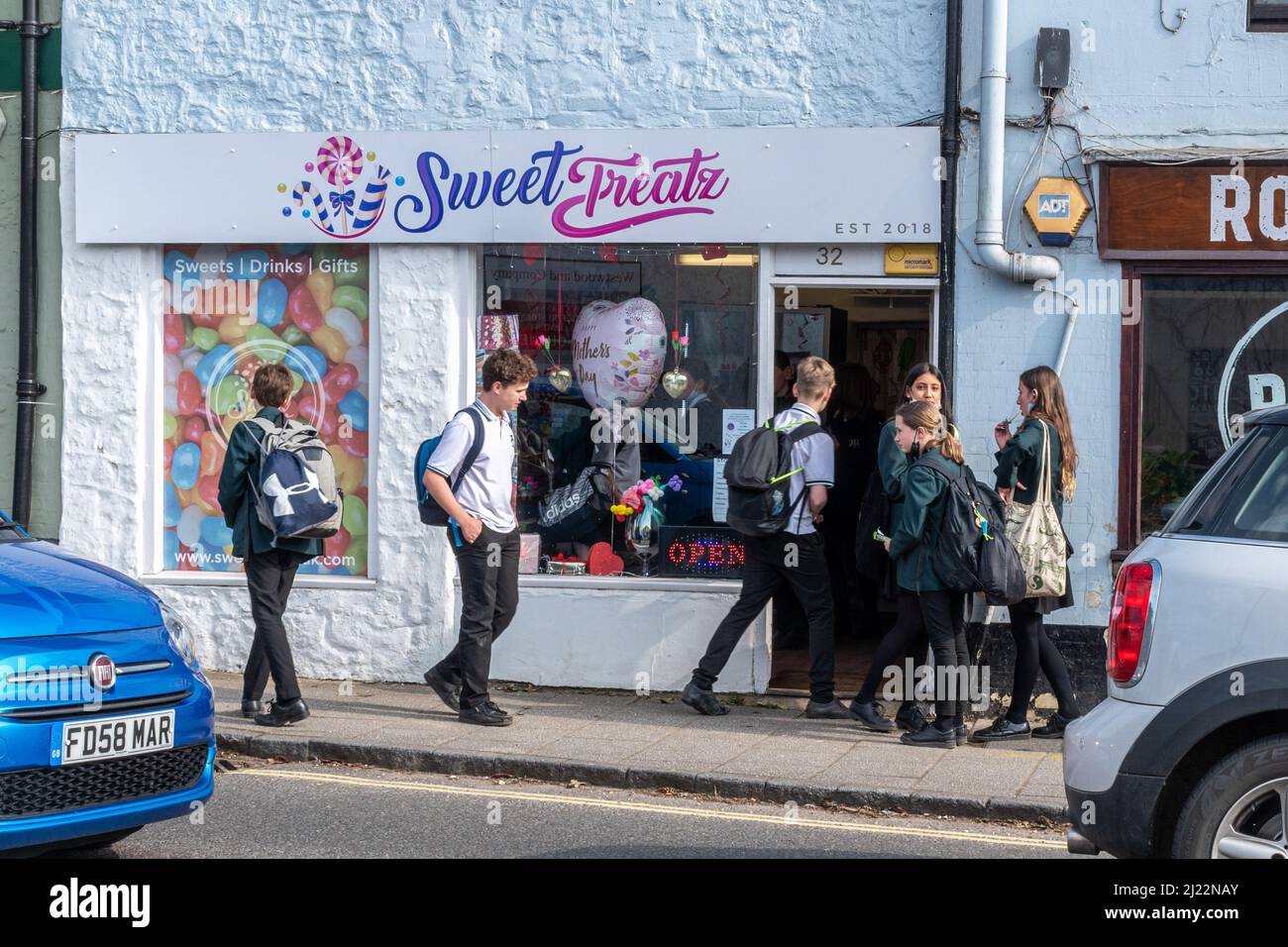 Schulkinder vor einem Süßgeschäft auf dem Weg von der Schule nach Hause, kaufen ungesunde Lebensmittel, Liphook, Hampshire, Großbritannien Stockfoto
