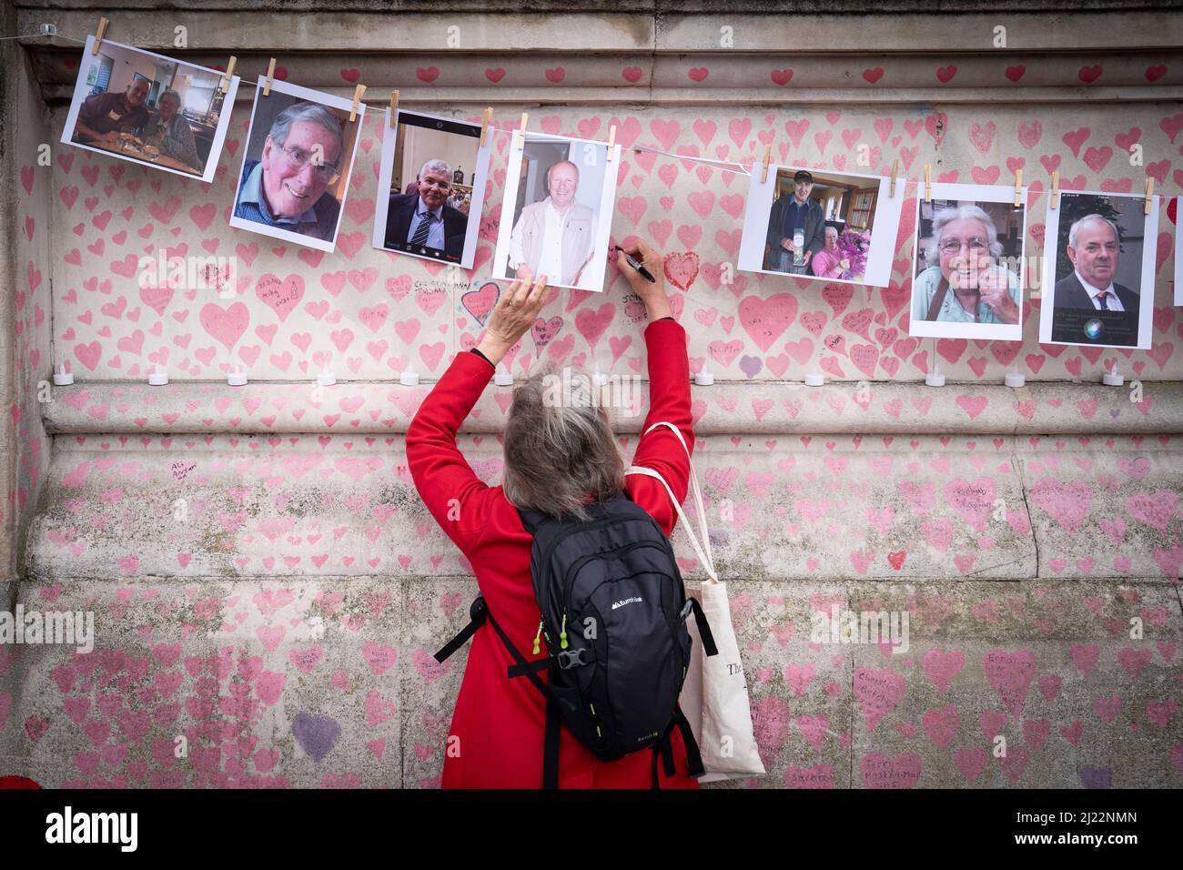 Ein Familienmitglied zahlt seinen Respekt für diejenigen, die Covid 19 ihr Leben verloren haben, während sie den einjährigen Jahrestag der National Covid Memorial Wall, London, begehen. Bilddatum: Dienstag, 29. März 2022. Stockfoto
