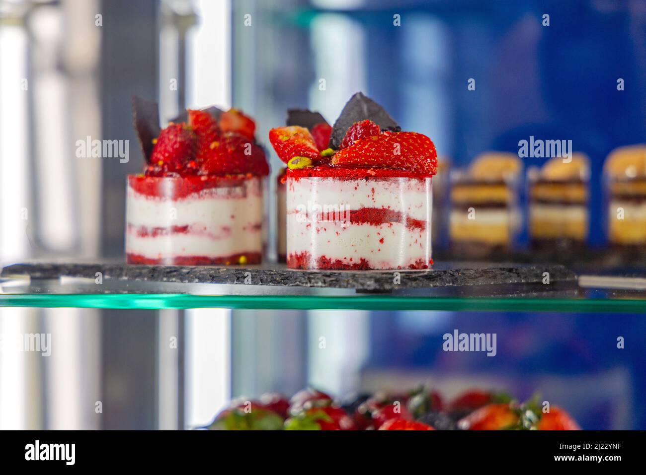 Kleine Kuchen mit Erdbeeren im Regal im Kühlschrank Stockfoto