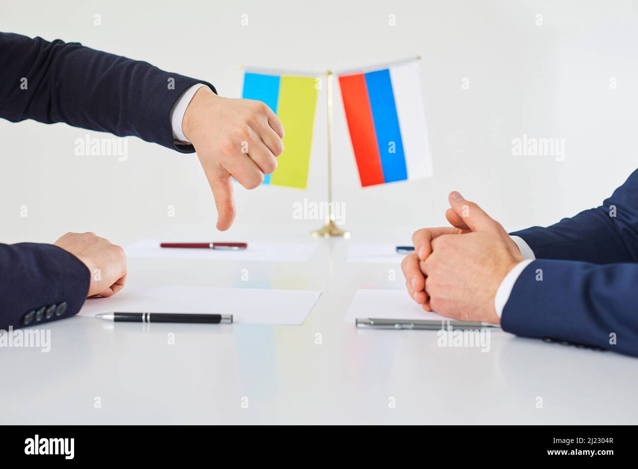 Vertreter der ukrainischen Seite bei Gesprächen drückt seine Unzufriedenheit aus, indem er mit dem Daumen nach unten zeigt. Stockfoto