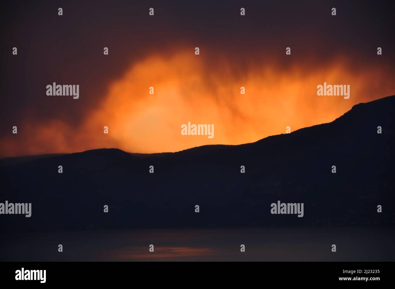 Intensiver roter und oranger Sonnenuntergang wie brennender Himmel im Winter.Sonnenuntergang nach den Bergen, wie Feuerflammen Stockfoto