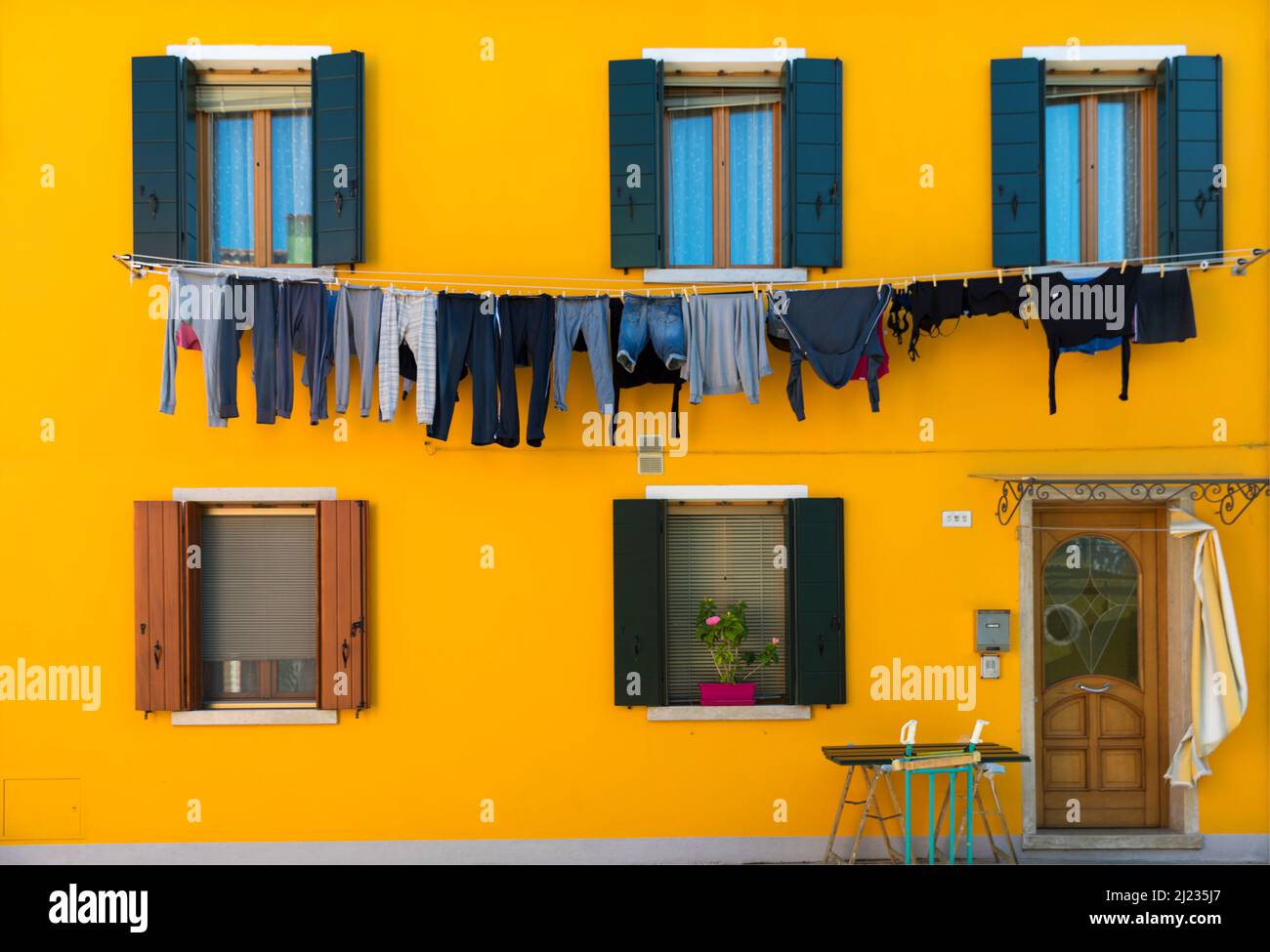 Italien, Venedig, farbenfrohe Häuser mit Wäschemöglichkeiten auf der venezianischen Insel Burano Stockfoto