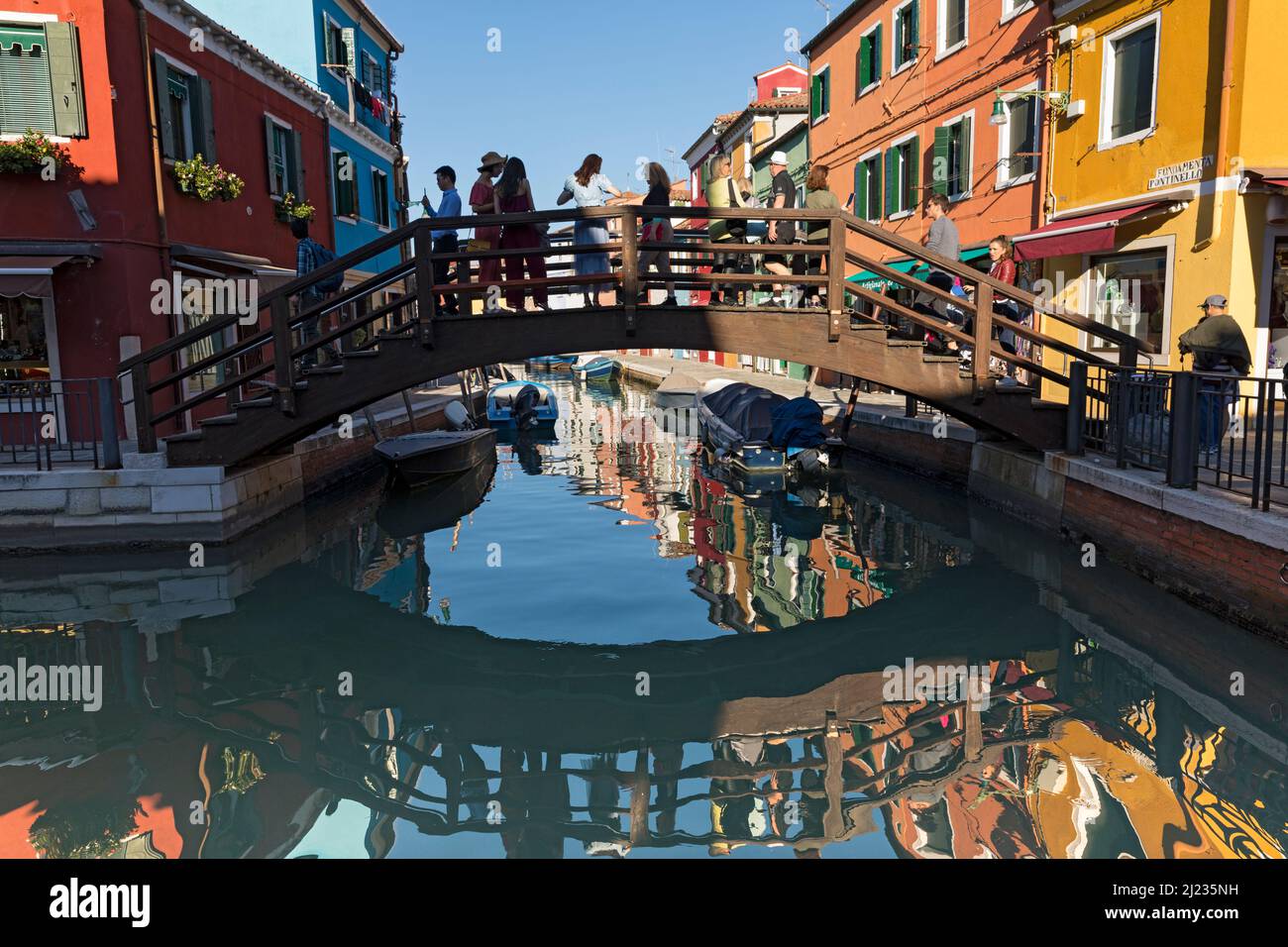 Italien, Venedig, farbenfrohe Häuser auf der venezianischen Insel Burano, die sich zu einem Kanal spiegeln Stockfoto