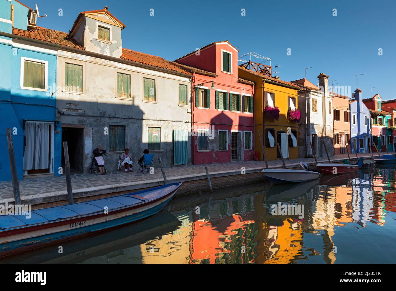 Italien, Venedig, farbenfrohe Häuser auf der venezianischen Insel Burano, die sich zu einem Kanal spiegeln Stockfoto