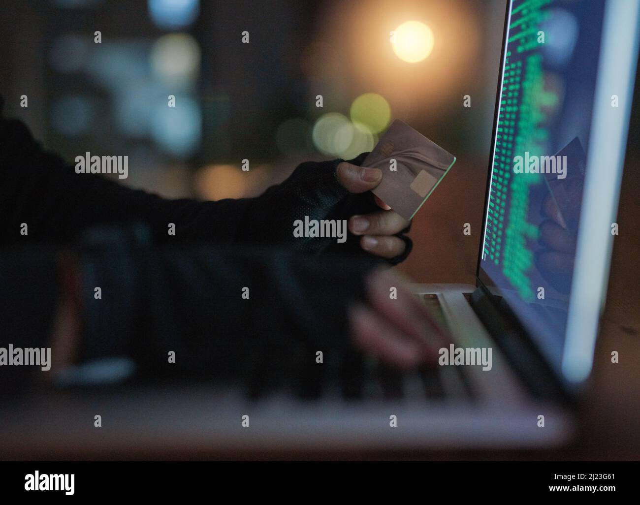Hacker können viel tun, ohne dass Sie etwas wissen. Aufnahme eines nicht erkennbaren Hackers, der einen Laptop verwendet, um in ein Kreditkonto zu hacken. Stockfoto