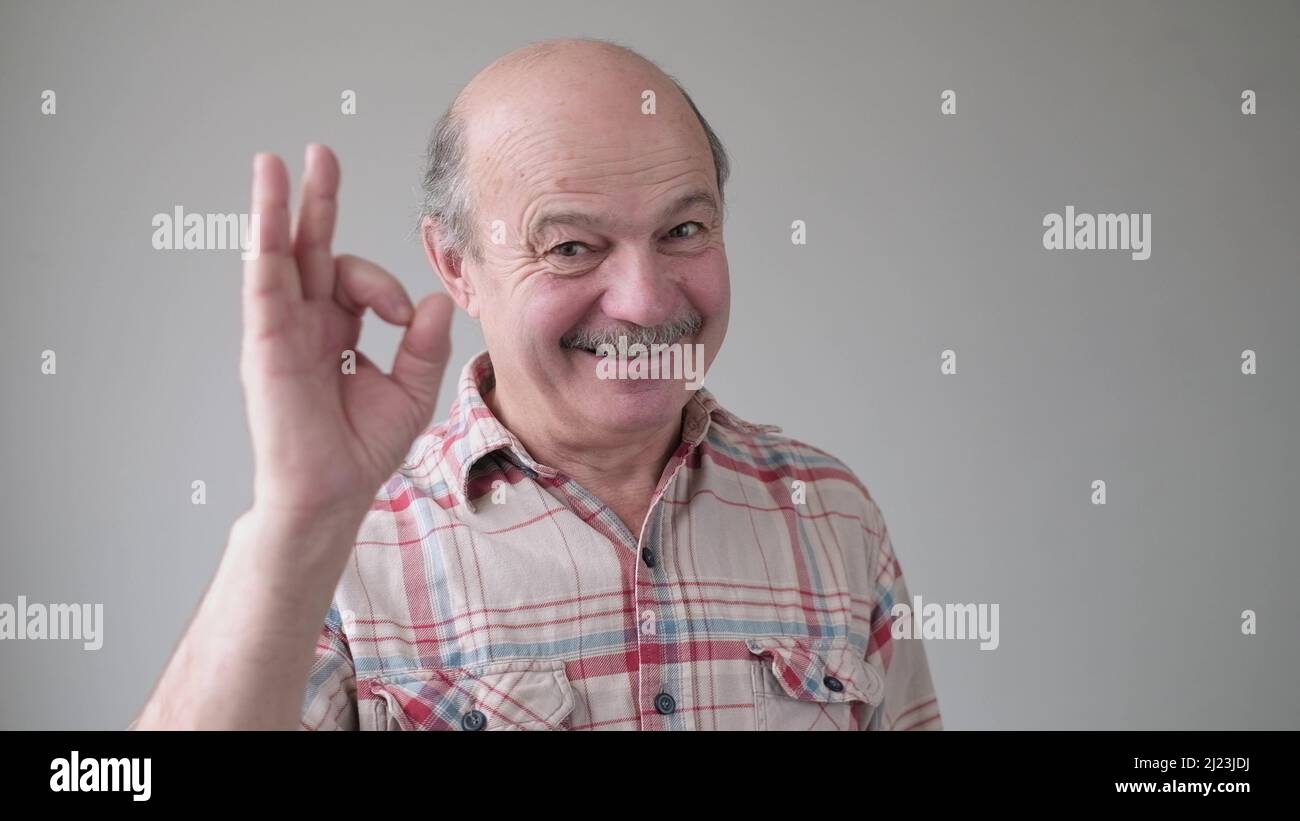 Gute Wahl glücklich, fröhlich, lächelnd, älterer hispanischer Mann, der ein OK-Zeichen zeigte. Positive menschliche Emotionen, Mimik. Studioaufnahme Stockfoto