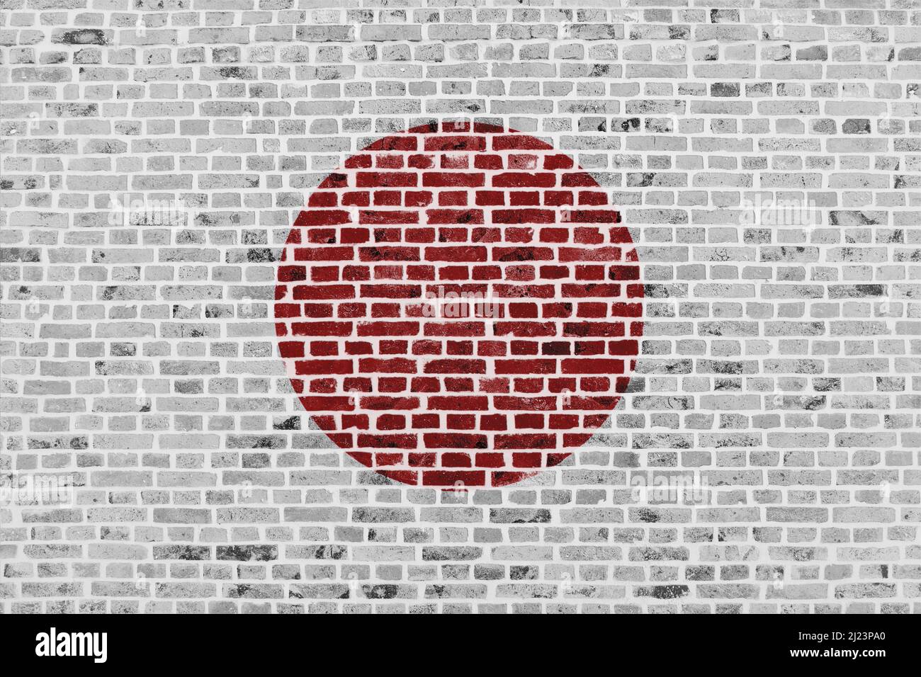 Nahaufnahme einer Backsteinmauer mit der Flagge Japans. Stockfoto