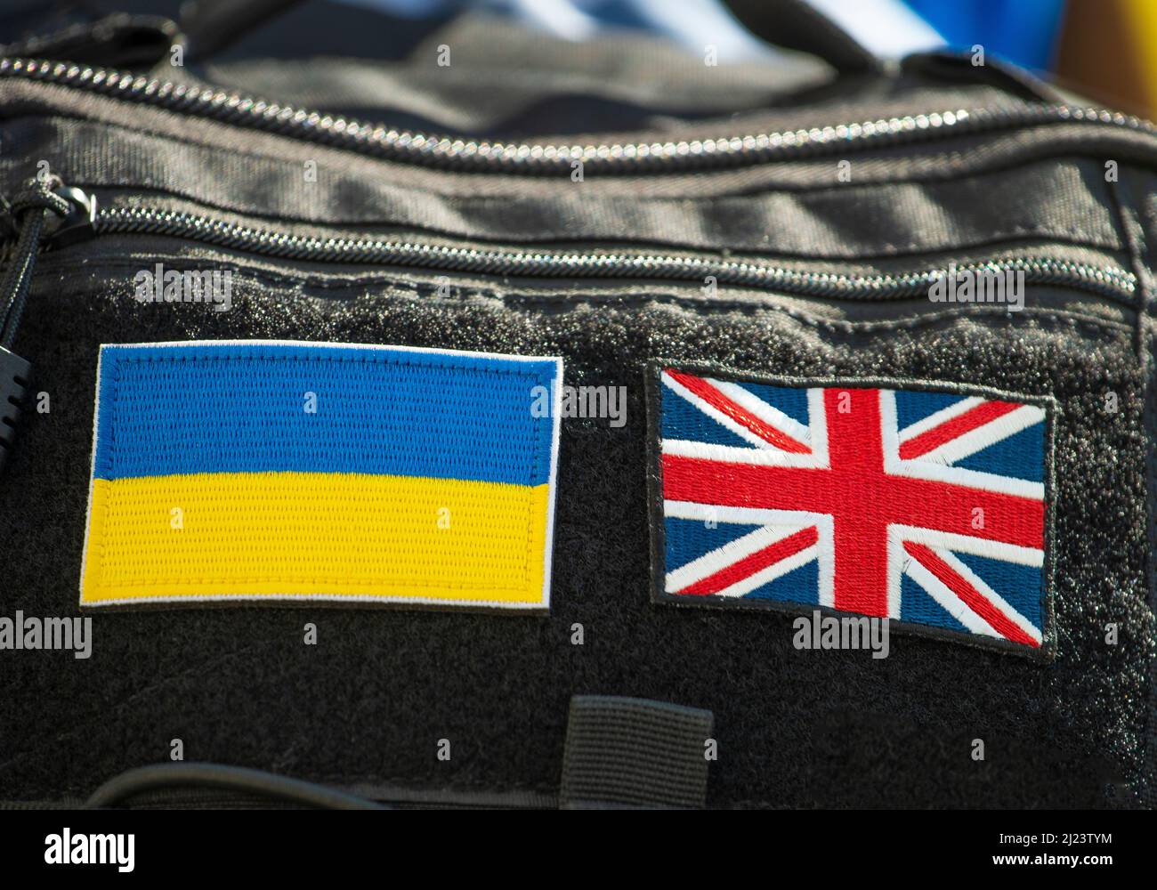 Stoffaufnäher der Flaggen des Vereinigten Königreichs und der Ukraine, seitlich an der Rückseite eines schwarzen Rucksacks angebracht. Stockfoto