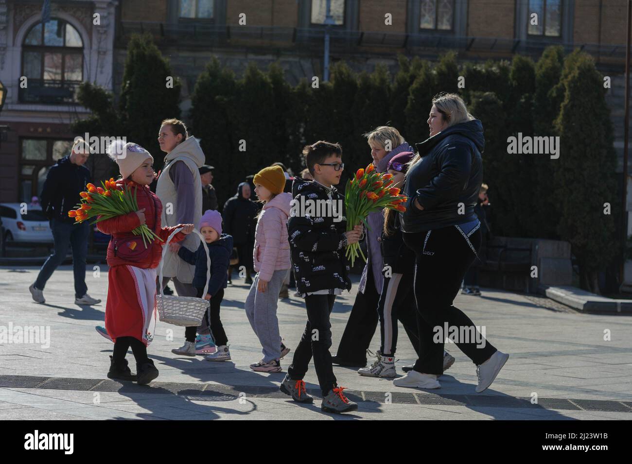 Lviv, Ukraine. 27. März 2022. Kinder laufen umher und verkaufen Blumen, um Geld zu sammeln, um kugelsichere Westen für ukrainische Soldaten zu kaufen. Russland marschierte am 24. Februar 2022 in die Ukraine ein und löste damit den größten militärischen Angriff in Europa seit dem Zweiten Weltkrieg aus (Bild: © Mykola Tys/SOPA Images via ZUMA Press Wire) Stockfoto