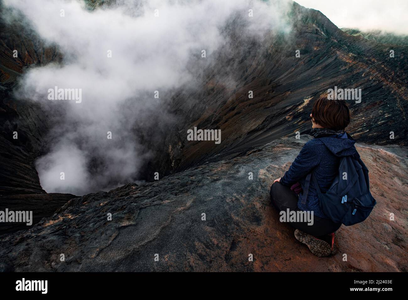 Mädchen, das in den Krater des Vulkans Bromo schaut Stockfoto
