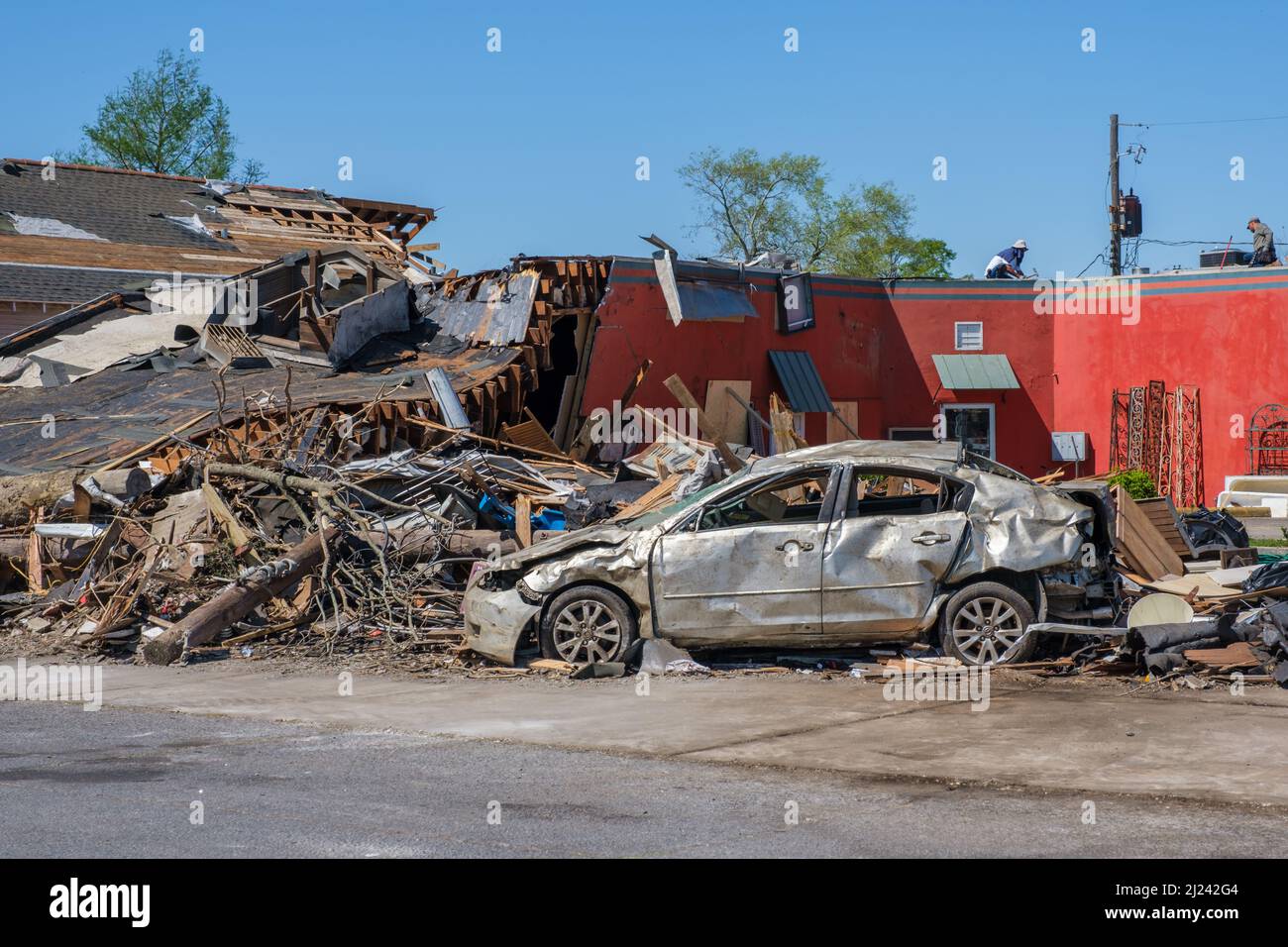 ARABI, LA, USA - 26. MÄRZ 2022: Trümmerhaufen und schwer beschädigtes Auto in der Nähe eines unbeschädigten Geschäfts auf der Friscoville Avenue, nachdem der Tornado niedergeschlagen war Stockfoto