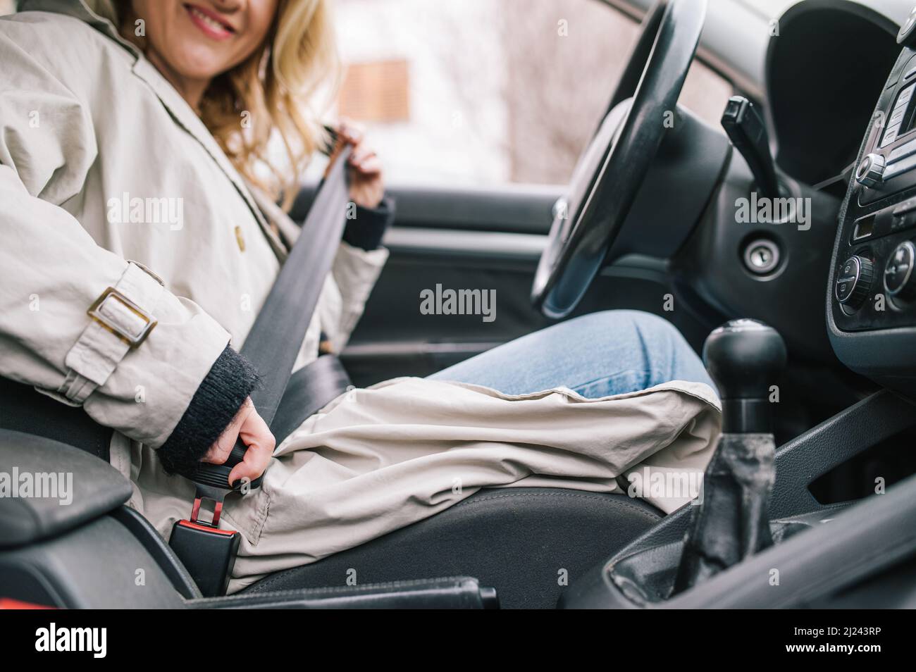 Eine Amateurfahrerin befestigt ihren Sicherheitsgurt und sorgt für die Verkehrssicherheit. Sicherheitsgurt im Auto anlegen. Stockfoto