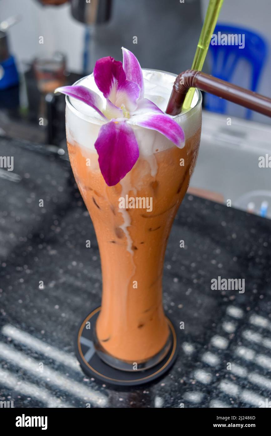Thai-Eistee mit Orchideengarnitur Stockfoto