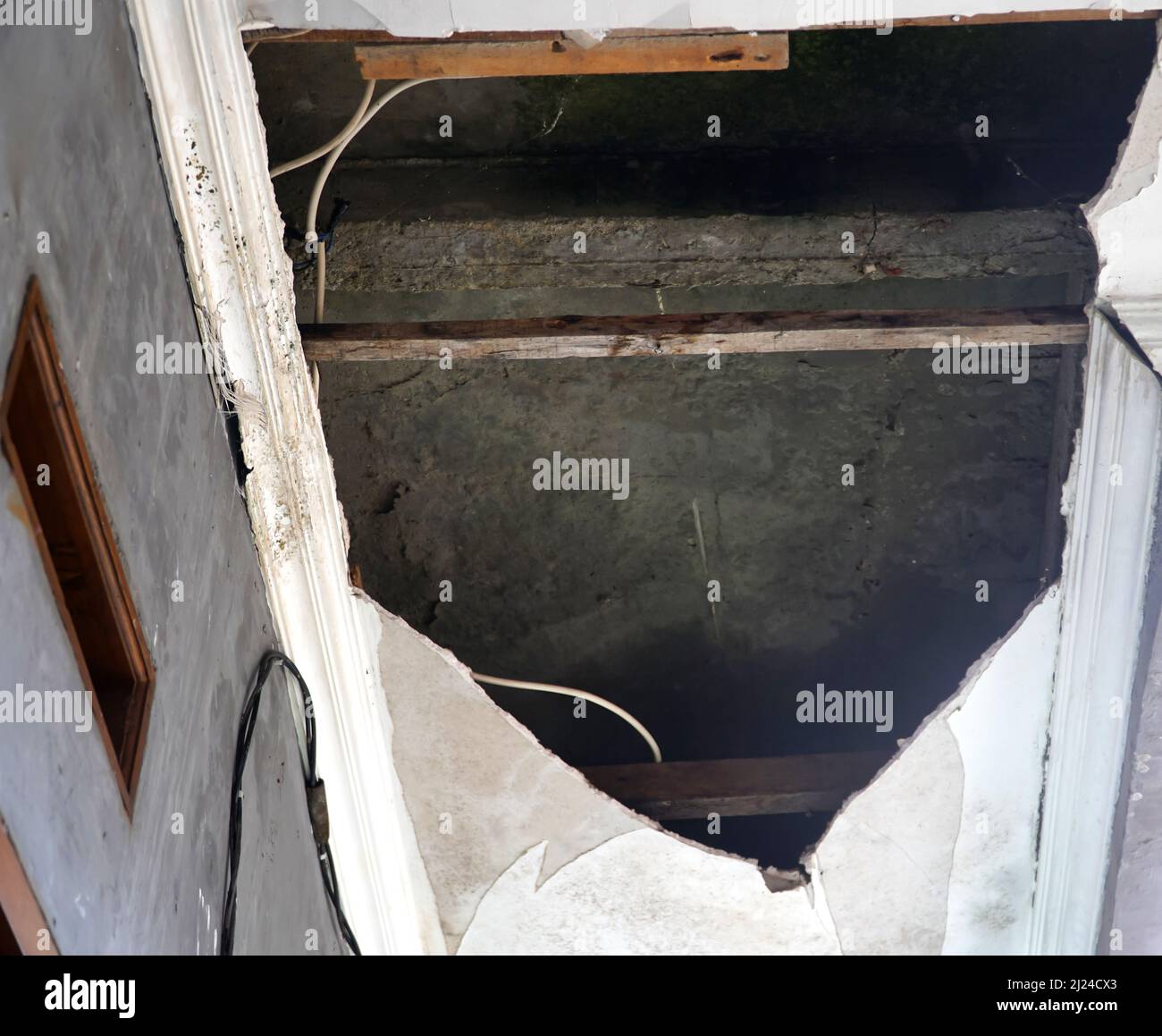 Schäden an der Decke, die ihren Holzrahmen durch Wasserlecks aufweist Stockfoto