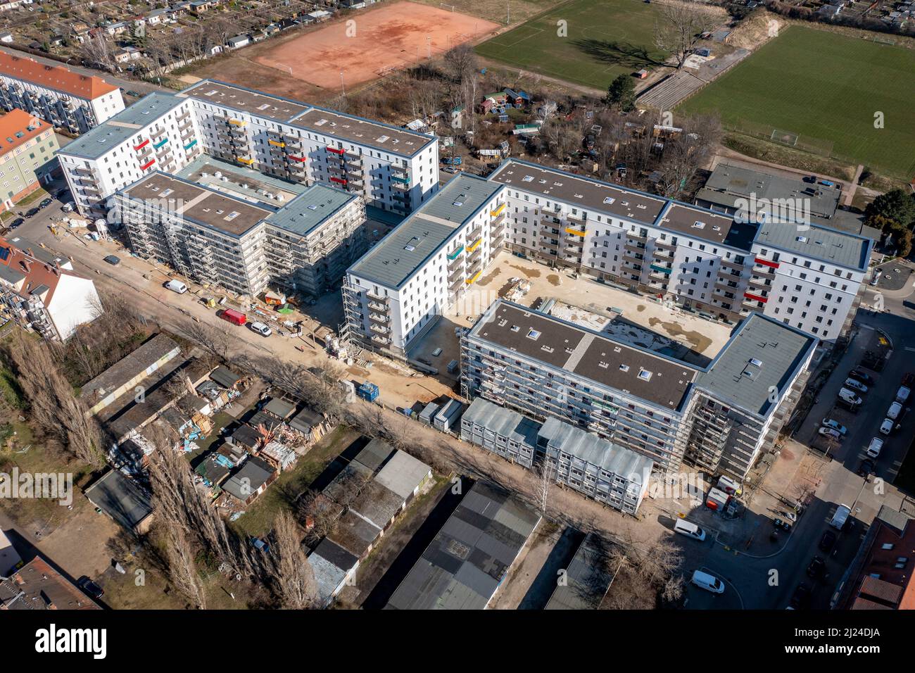 08. März 2022, Sachsen, Leipzig: Nach dem teilweisen Ausbau des Gerüsts sind die Neubauten der Leipziger Wohnungs- und Baugesellschaft (LWB) in der Saalfelder Straße erstmals richtig zu sehen. Die neue Wohnanlage mit 300 Wohnungen besteht aus 18 Häusern, die in sechs Blöcken um zwei Wohnhöfe angeordnet sind. Eine Tiefgarage bietet Platz für 170 Fahrzeuge. Voraussetzung für den Einzug ist eine Bescheinigung über die Wohnberechtigung. Nach zuletzt stagnierenden Zahlen hat sich der Sozialwohnungsbestand in Sachsen etwas erholt. (Luftaufnahme mit Drohne) P Stockfoto