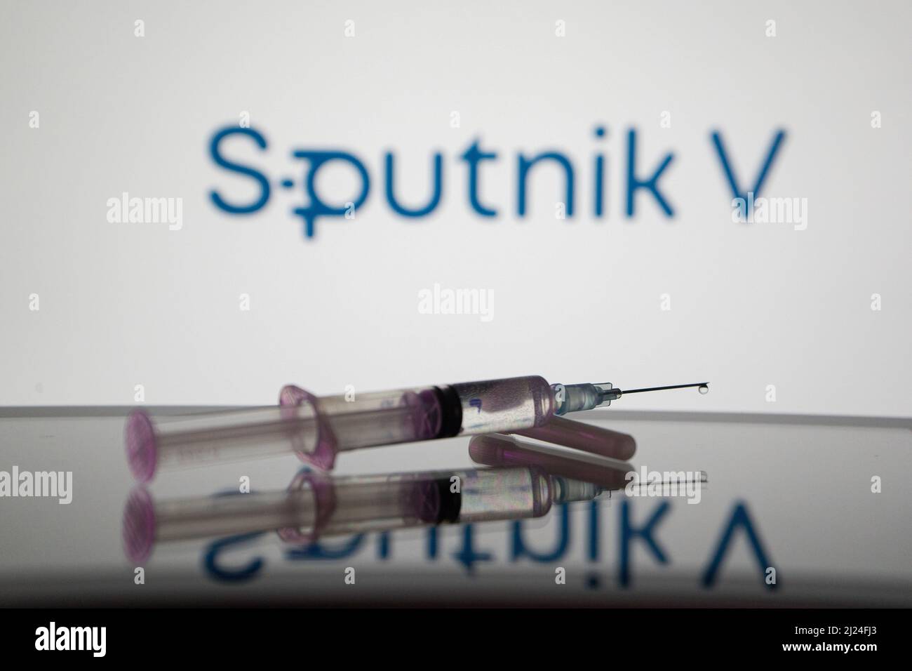 Griechenland. 29. März 2022. In dieser Abbildung ist eine medizinische Spritze auf einem Bildschirm zu sehen und das Logo von Sputnik V im Hintergrund. (Foto von Nikos Pekiaridis/SOPA Images/Sipa USA) Quelle: SIPA USA/Alamy Live News Stockfoto