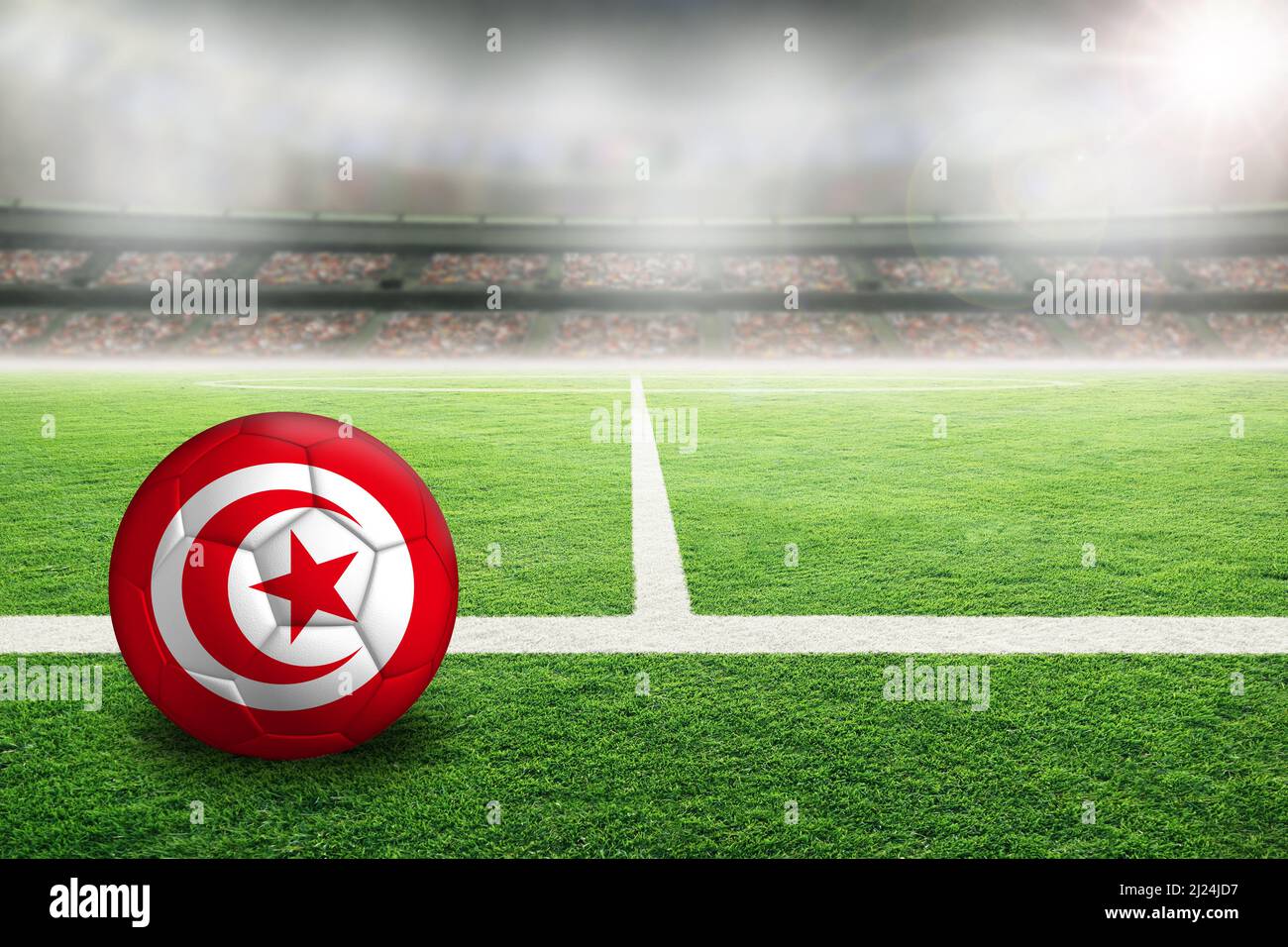 Fußball im hell erleuchteten Außenstadion mit der Flagge Tunesiens. Fokus auf Vordergrund und Fußball mit geringer Schärfentiefe auf Hintergrund A Stockfoto