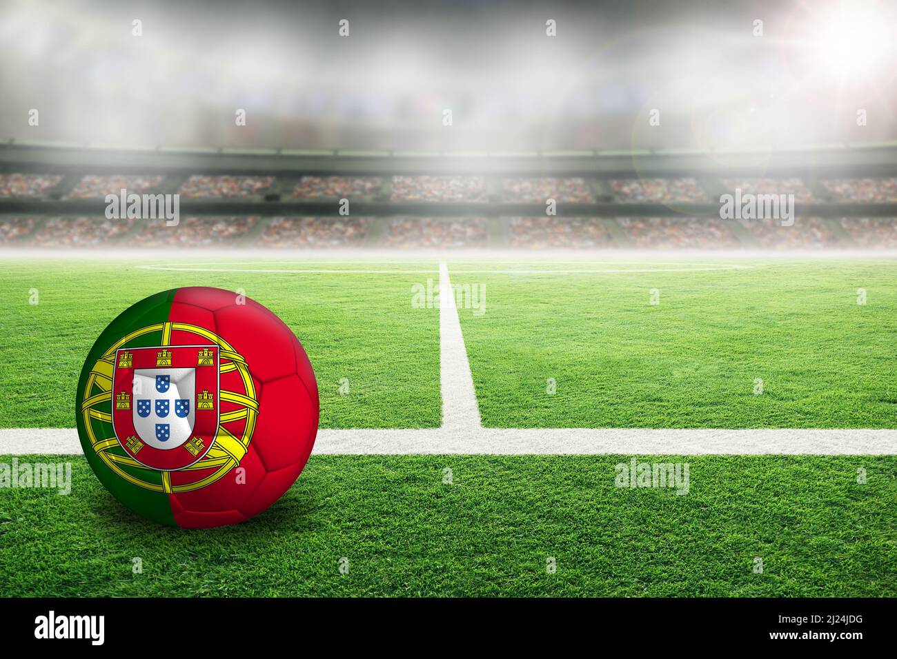 Fußball im hell erleuchteten Stadion mit der Flagge Portugals. Konzentrieren Sie sich auf den Vordergrund und den Fußball mit geringer Schärfentiefe im Hintergrund Stockfoto