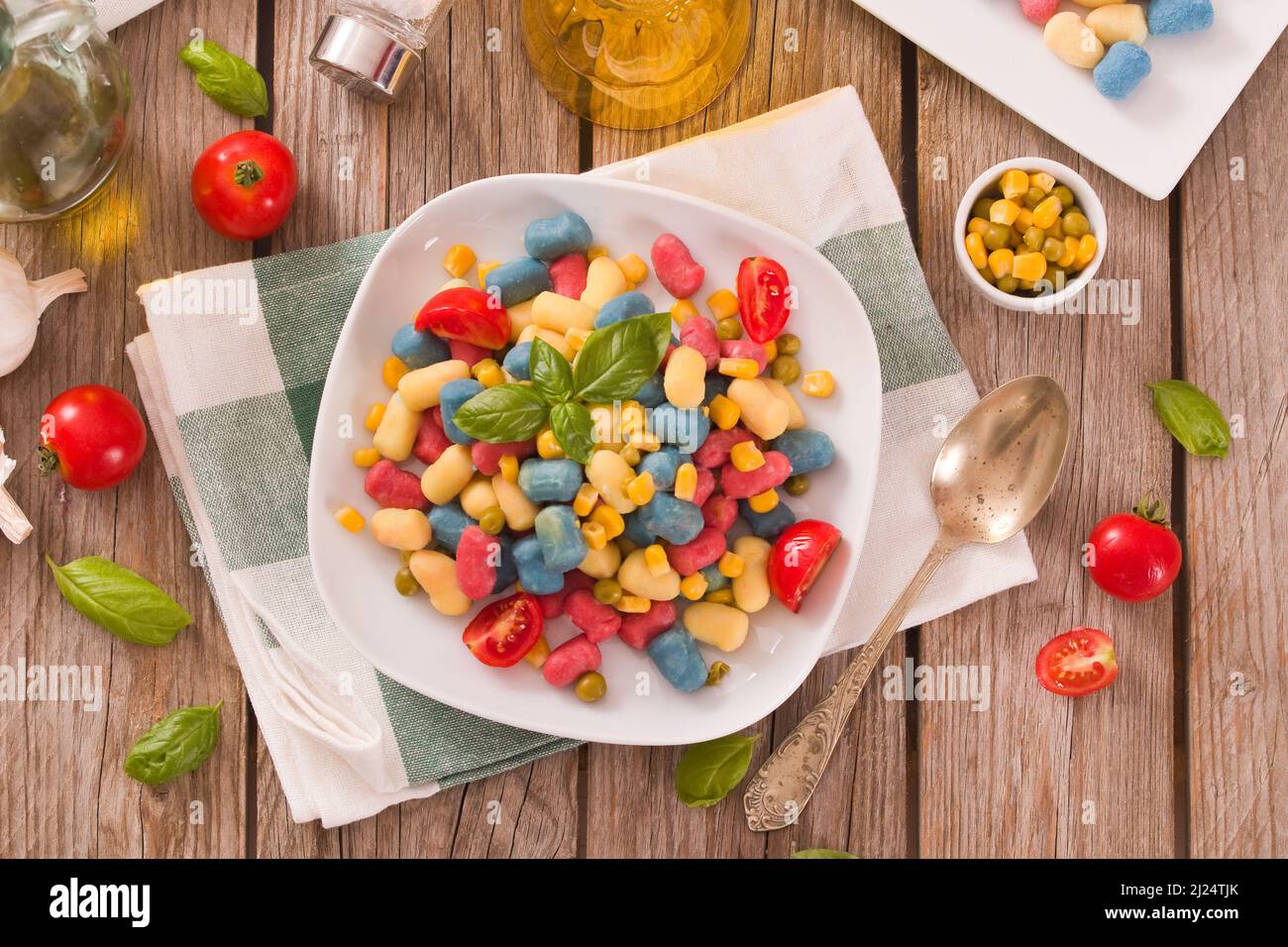 Farbige Gnocchi mit Gemüse und süßem Mais. Stockfoto