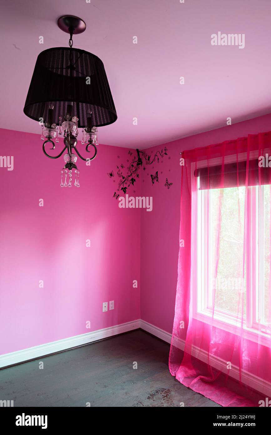 Ein helles, pinkes Schlafzimmer mit schwarzer Leuchte. Dieses Haus wurde seitdem abgerissen. Stockfoto