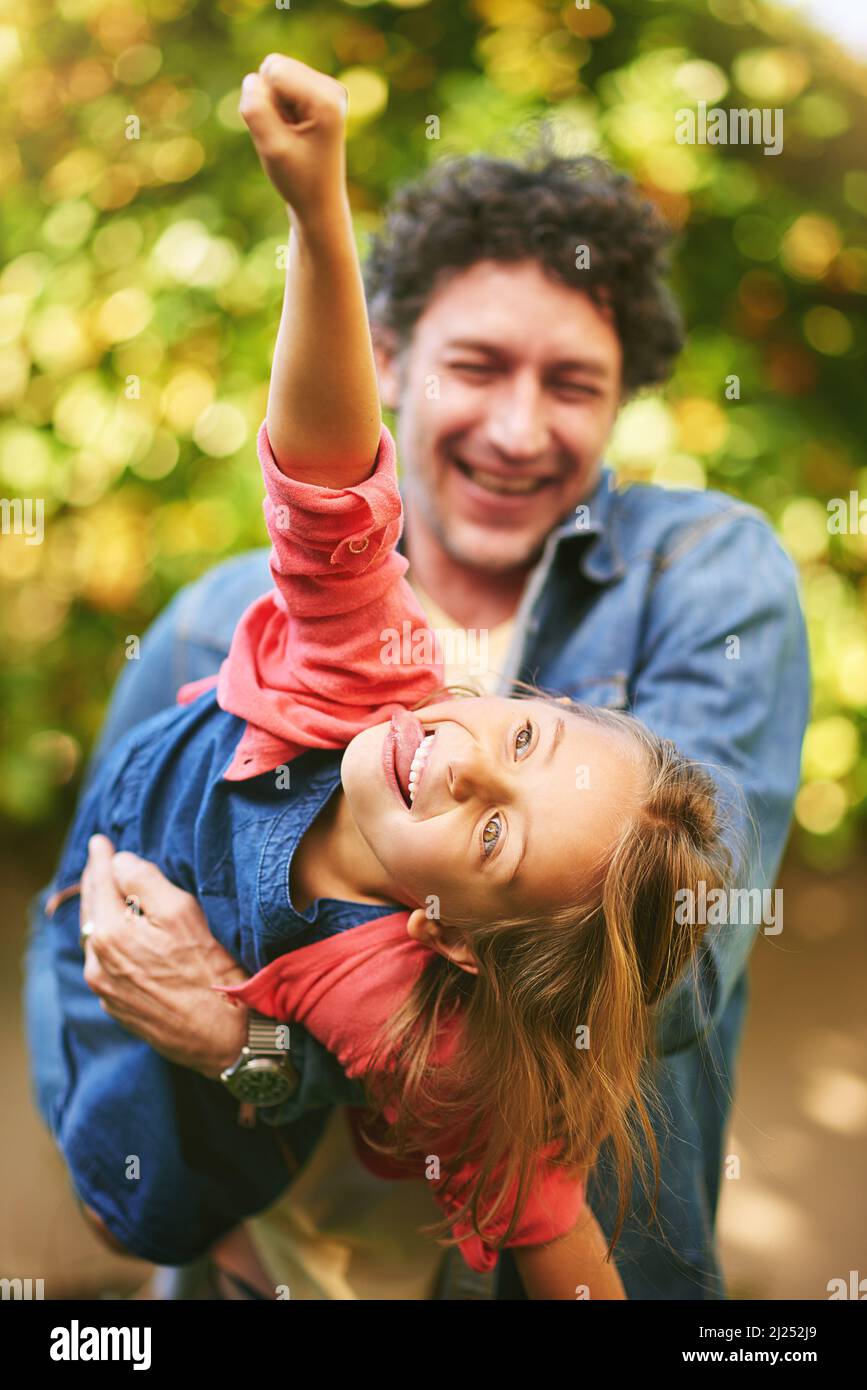 Fliegen bis in die Unendlichkeit und darüber hinaus. Ausgeschnittene Aufnahme eines Vaters und einer Tochter, die im Freien spielen. Stockfoto