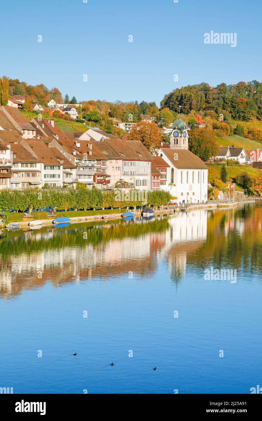 Blick vom Rheinufer über den Rhein in die Altstadt von Eglisau mit Spiegelung auf dem Wasser. Kanton Zürich, Schweiz Stockfoto