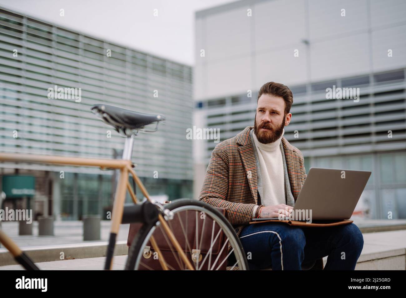 Creative Director sitzt im Business Center-Bereich mit Laptop und Handy. Arbeiten im Freien Stockfoto
