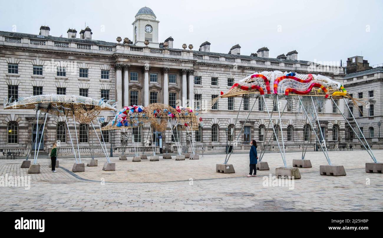 London UK 30 March 2022 Somerset House präsentiert die Arks of Gimokudan des brillanten philippinischen Künstlers Leeroy New, die noch bis zum 26. April anlässlich des Earth Day zu sehen sein wird. Es handelt sich um die erste britische Installation von New, die in Form von drei fantastischen, hochgedrehten Schiffen, die aus Plastikabfällen und recycelten Materialien gebaut wurden, in einem Höhenmeter vom Boden entfernt entsteht. Die Installation greift die Kultur und Mythologien der Heimat des Künstlers auf den Philippinen auf, einem Land an der vordersten Front der Klimanotlage. Paul Quezada-Neiman/Alamy Live News Stockfoto