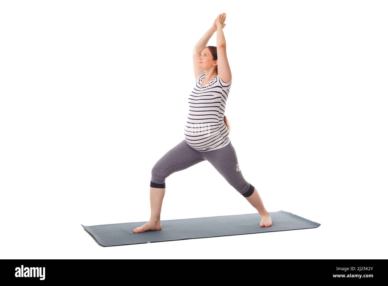 Schwangere beim Yoga Asana Virabhadrasana 1 Stockfoto