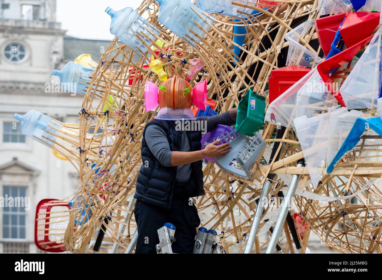 London, Großbritannien. 30. März 2022. Der philippinische Künstler Leeroy New posiert auf ‘The Arks of Gimokudan’, seine Installation wurde anlässlich des Earth Day im Somerset House enthüllt. Dies ist New’s erste britische Installation und umfasst drei fantastische, umgedrehte Schiffe, die aus Kunststoffabfällen und recycelten Materialien gebaut wurden. Die Installation, die bis zum 26. April zu sehen ist, greift auf die Kultur und Mythologien der Philippinen zurück, einem Land an der vordersten Front des Klimanotstands.Quelle: Stephen Chung / Alamy Live News Stockfoto