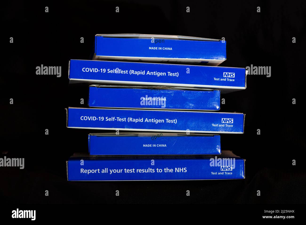 Blaue NHS Covid-19-Testkits für lateralen Fluss/Coronavrus-Testkits für schnelles laterales Flussantigen vor schwarzem Hintergrund Stockfoto