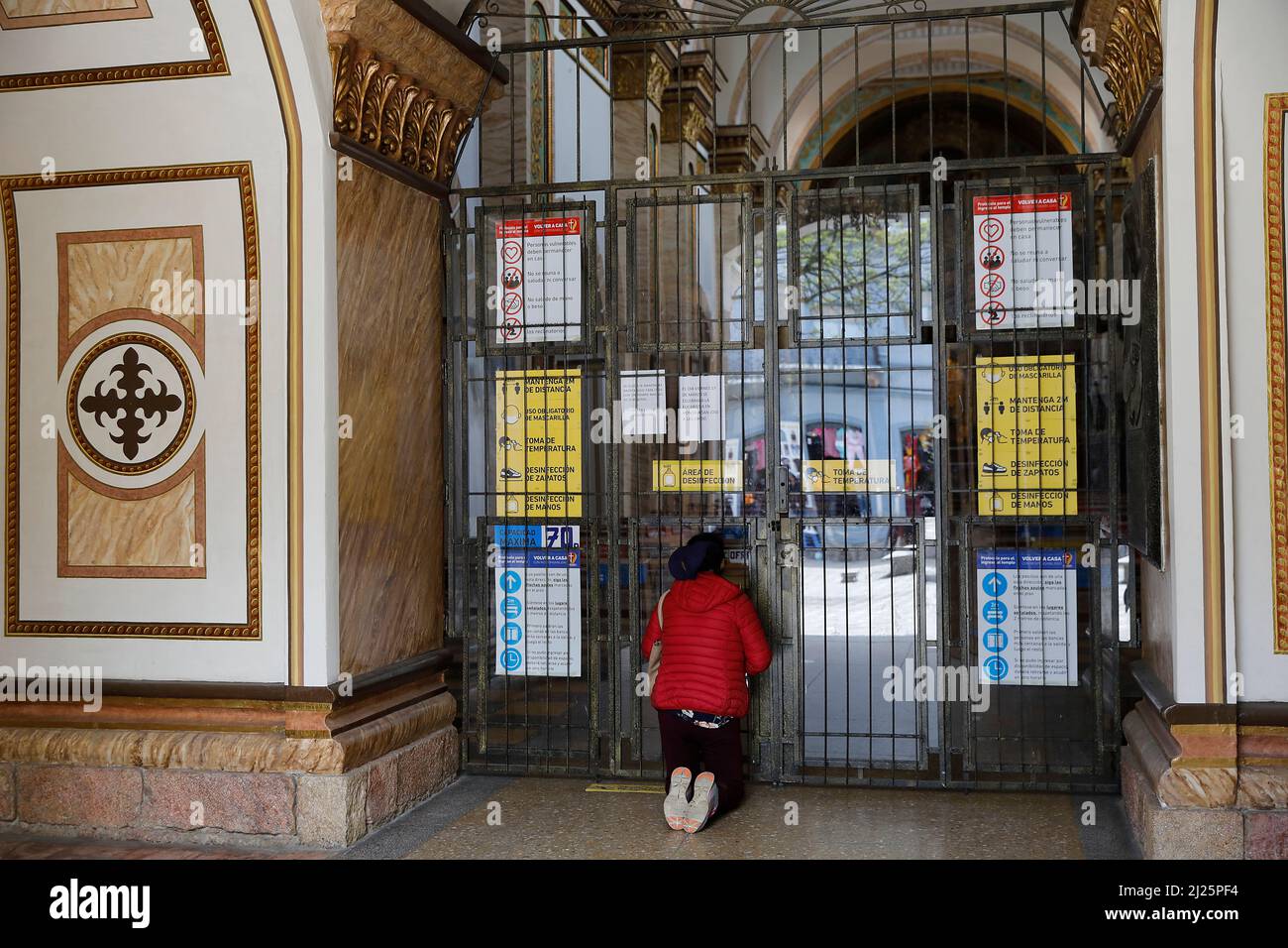 Frau, die vor einer geschlossenen Kirche in Cuenca, ecuador, betet Stockfoto