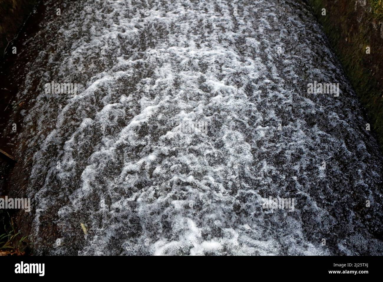 Unruhigen Wasser mit Kopf aus Schaum und Spray in weiß. Abstraktes Konzeptbild. Stockfoto