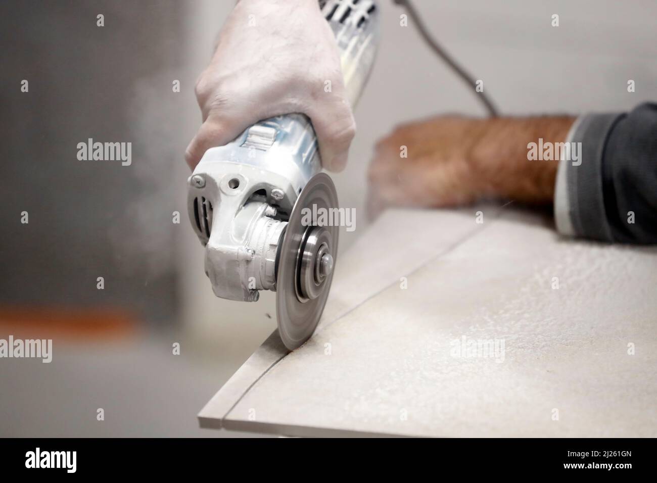 Baustelle. Neues Haus. Mann, der mit einer Kreissäge arbeitet. Stockfoto