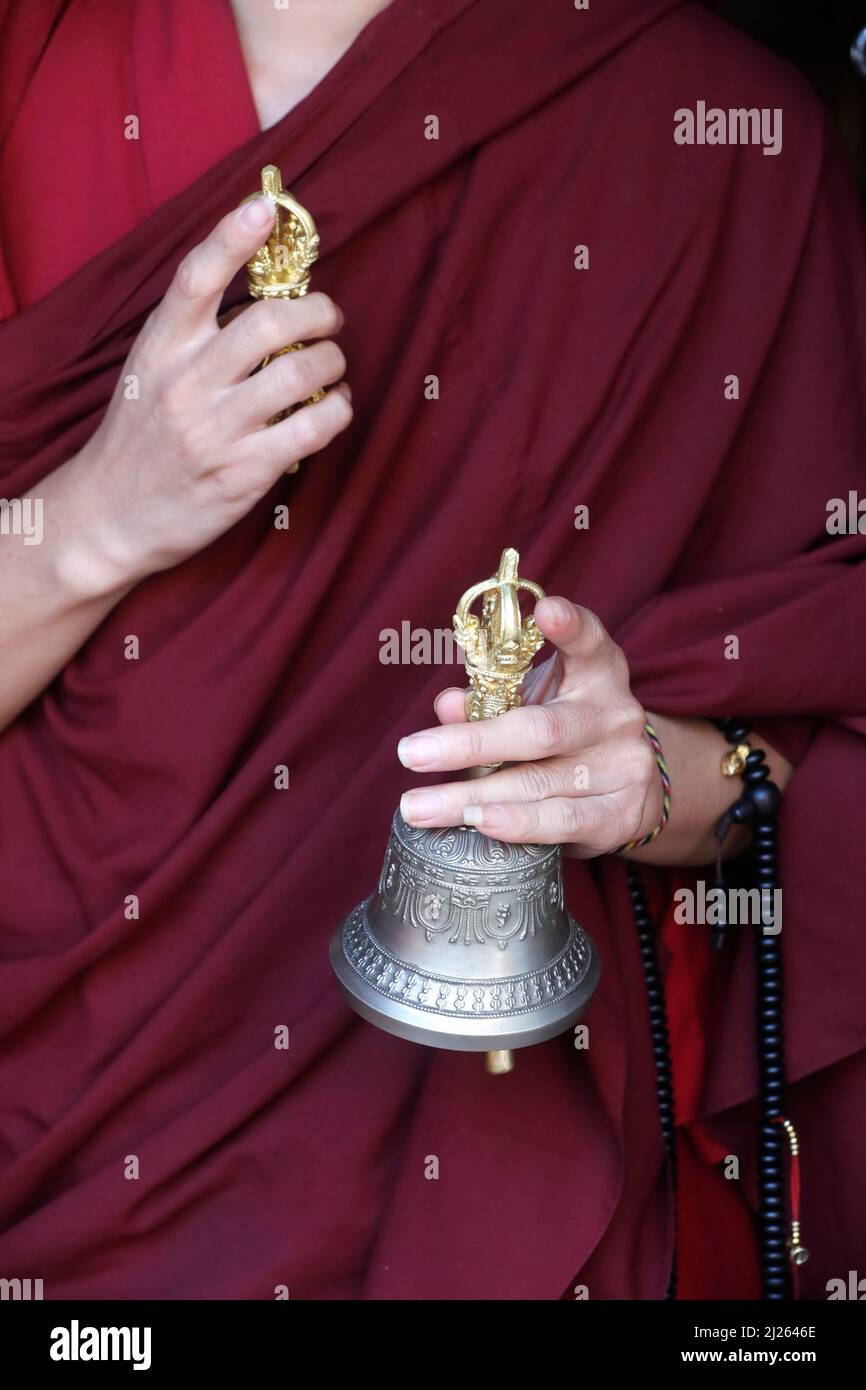 Kloster Pema Osel Ling. Buddhistischer Mönch in einem Lama-Kleid. Der Mönch hält die rituellen Attribute Buddhismus, Rosenkranz, Vajra, Glocke. Stockfoto