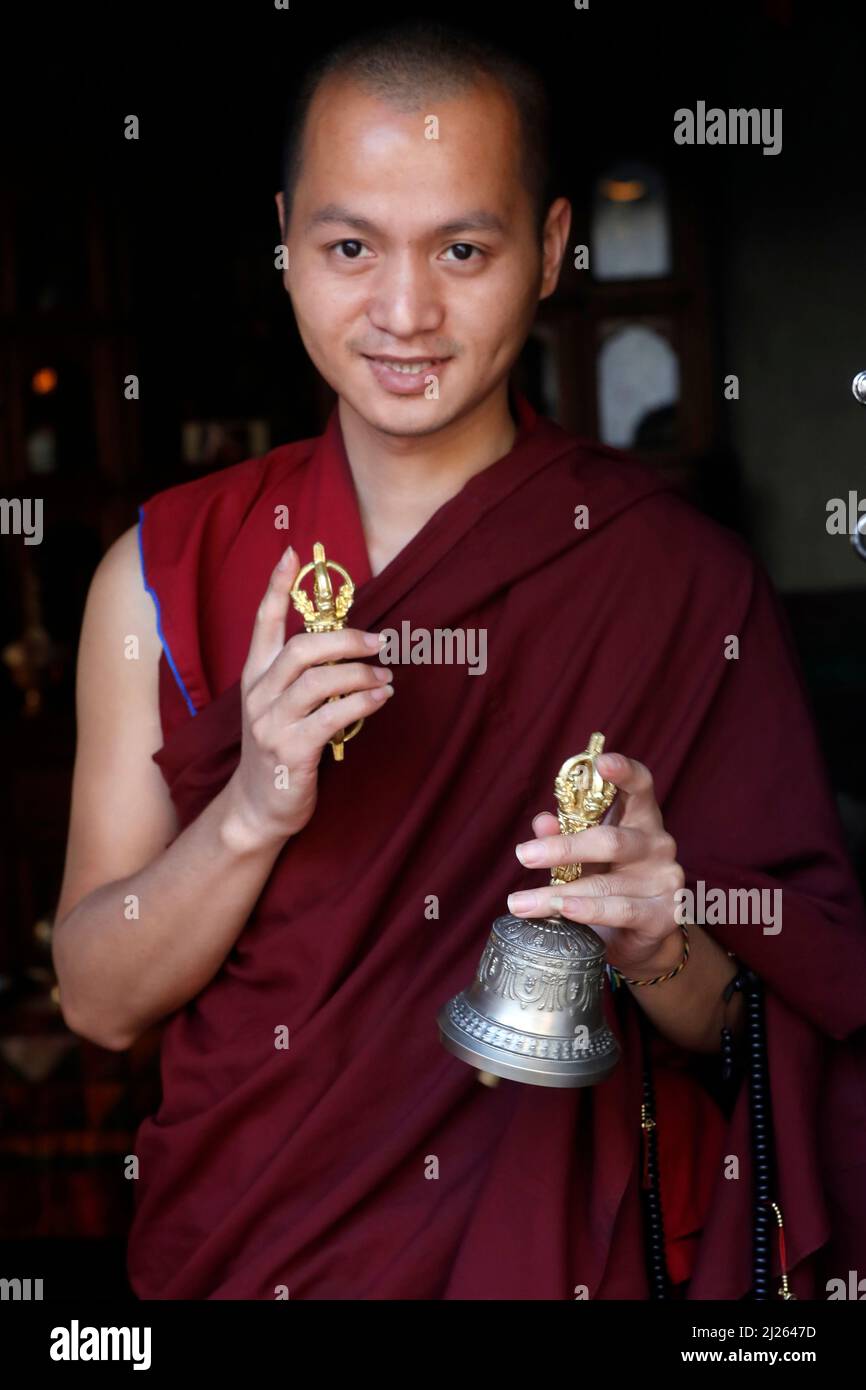 Kloster Pema Osel Ling. Buddhistischer Mönch in einem Lama-Kleid. Der Mönch hält die rituellen Attribute Buddhismus, Rosenkranz, Vajra, Glocke. Stockfoto
