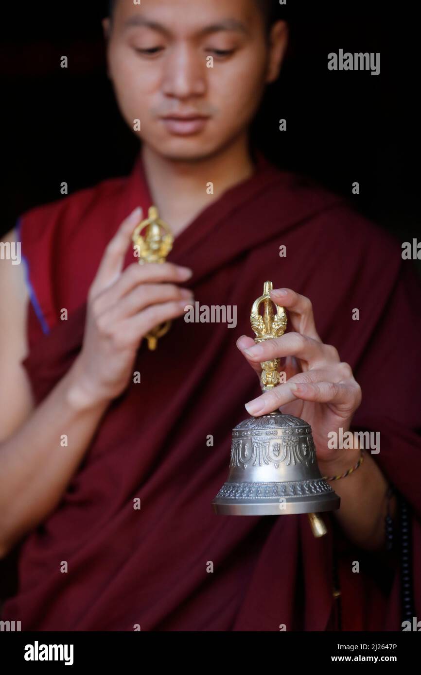 Kloster Pema Osel Ling. Buddhistischer Mönch in einem Lama-Kleid. Der Mönch hält die rituellen Attribute Buddhismus, Rosenkranz, Vajra, Glocke. Stockfoto