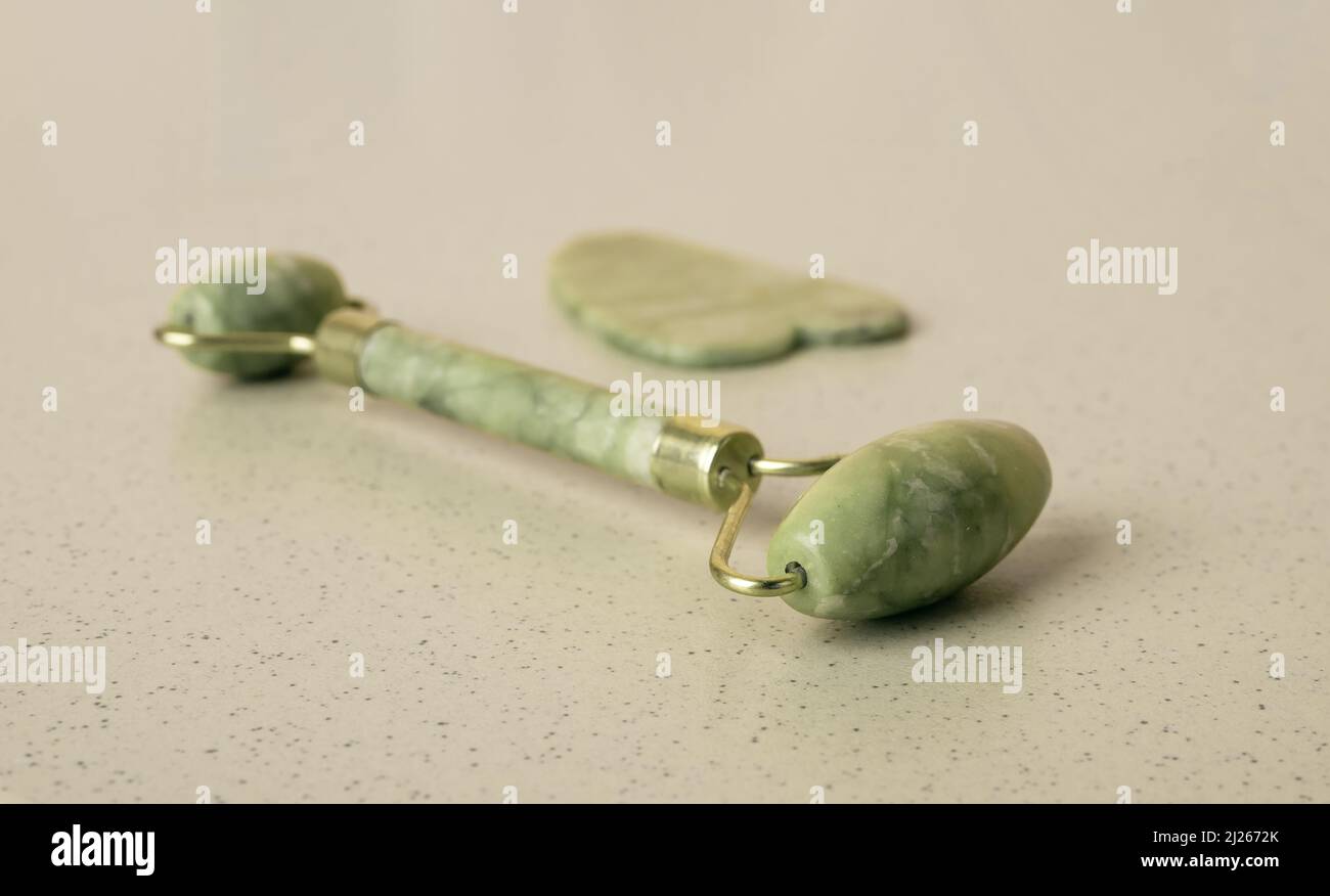 Gua Sha Scraping Massage-Werkzeug und Rolle. Gesichtsbeautheit, Hautpflege, Entspannungskonzept. Traditionelle Heilbehandlung. Hochwertige Fotos Stockfoto