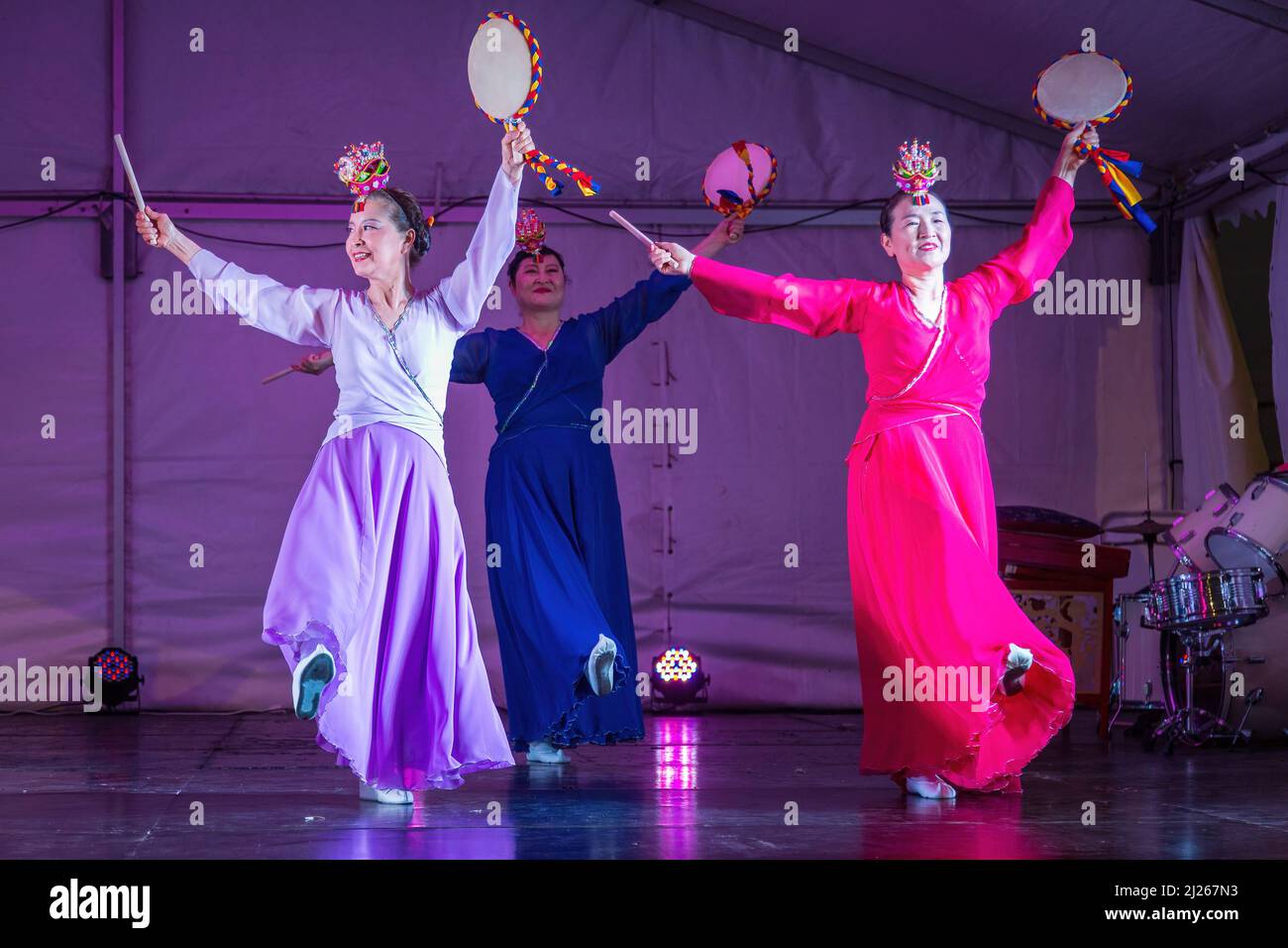 Koreanische Tänzerinnen in hanbok-Kleidern, die sogo (Handtrommeln) halten und auf der Bühne auftreten. Festlichkeiten im Herbst, Auckland, New Zelaand Stockfoto