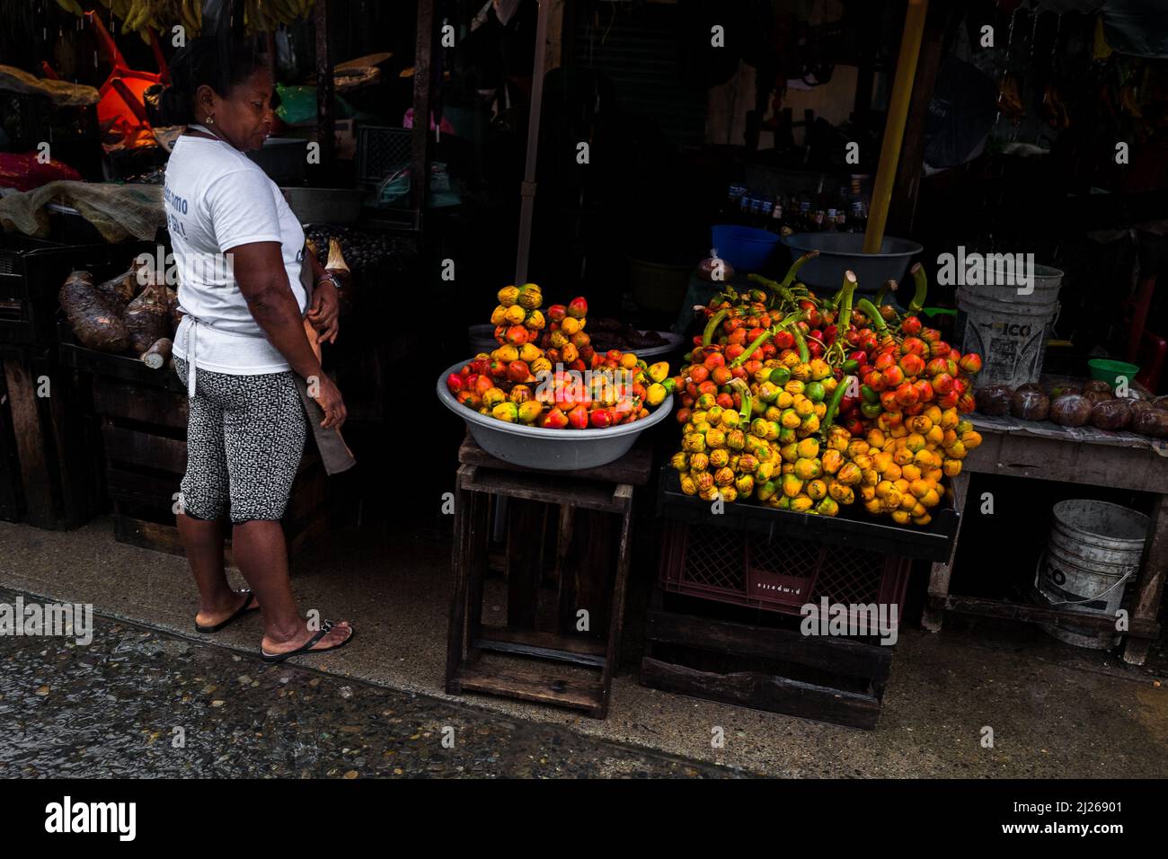 Eine afro-kolumbianische Frau verkauft auf dem Straßenmarkt in Quibdó, Chocó, Kolumbien, rohe Chontaduro-Früchte (Pfirsichpalme). Stockfoto