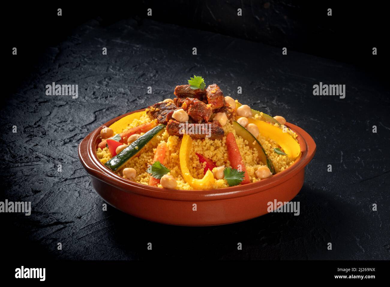 Fleisch- und Gemüsecouscous, festliche arabische Speisen mit Kichererbsen, auf dunklem Hintergrund Stockfoto