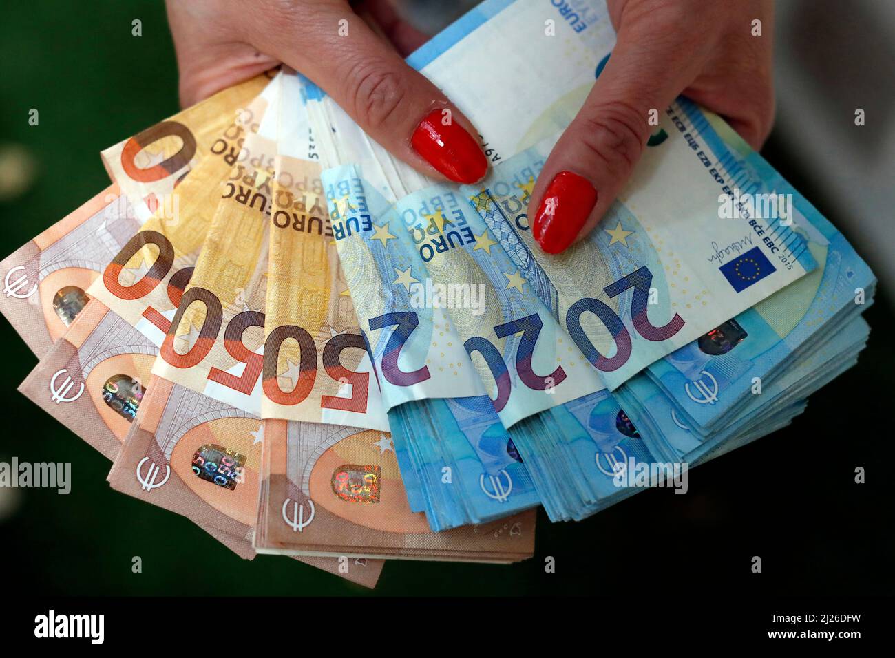 Frau mit Euro-Geldscheinen und -Banknoten. Konzept des Diebstahls von Bargeld, reichen Menschen, Ersparnissen oder Ausgaben von Geld. Zahlung wird gezählt. Stockfoto