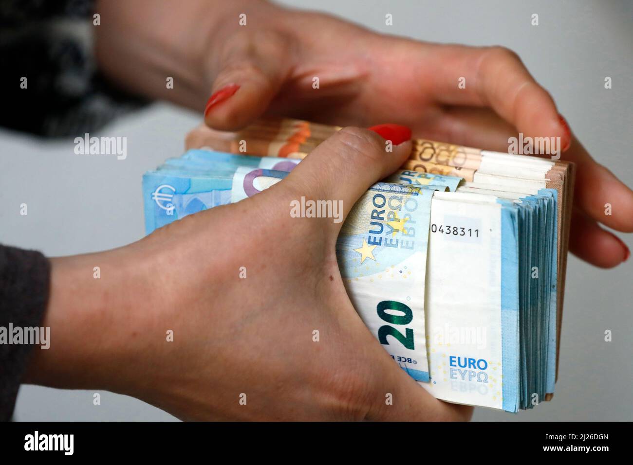 Frau mit Euro-Geldscheinen und -Banknoten. Konzept des Diebstahls von Bargeld, reichen Menschen, Ersparnissen oder Ausgaben von Geld. Zahlung wird gezählt. Stockfoto